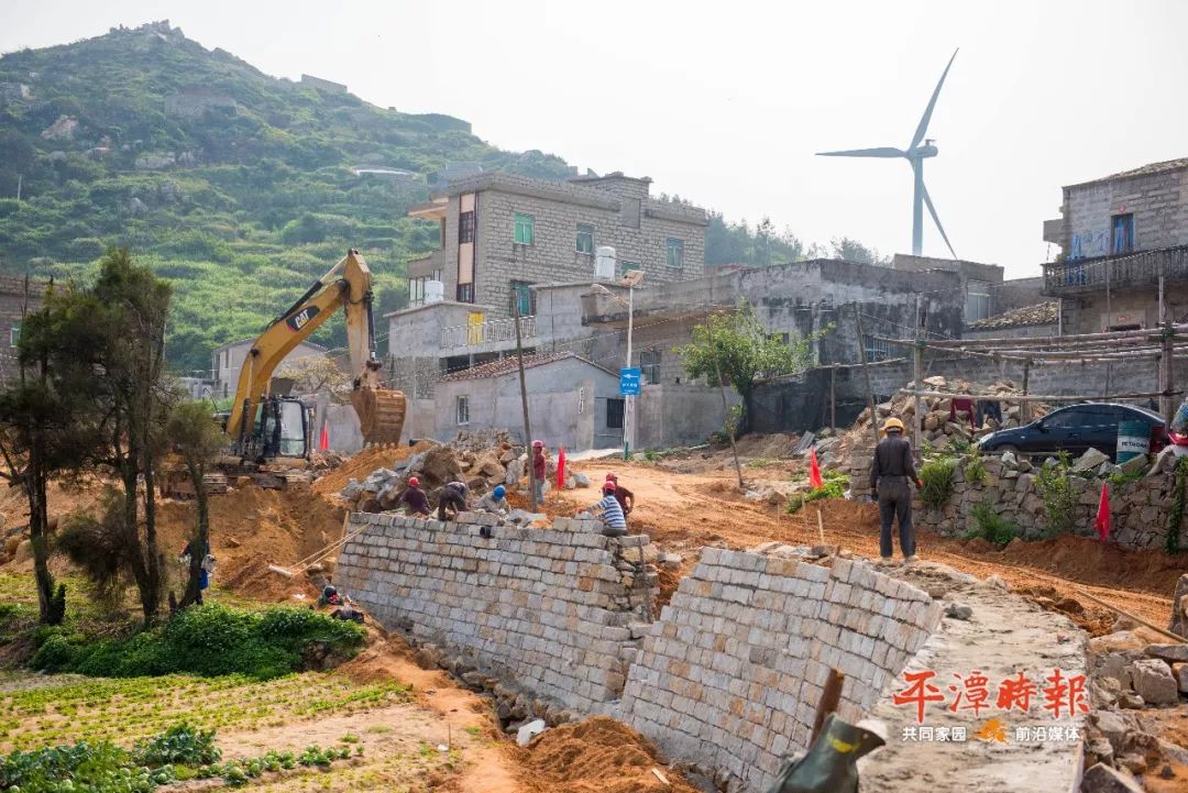 在白青乡青峰村的平潭北部生态廊道项目现场,施工车辆来回运送土石.