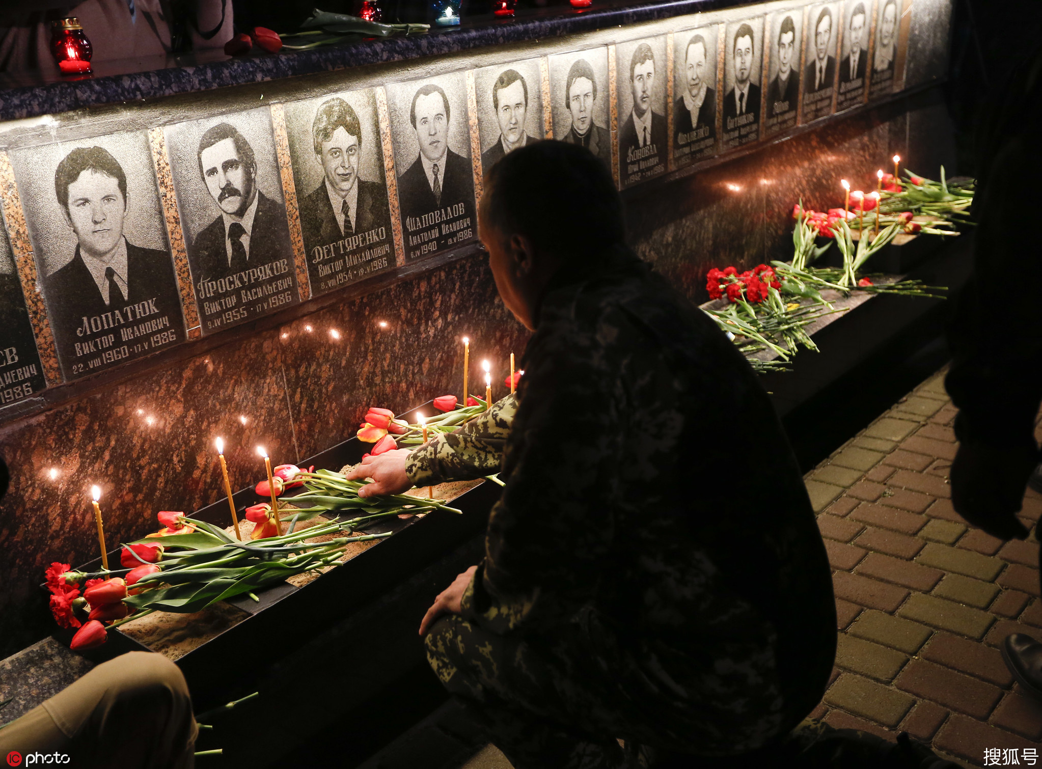 当地民众凌晨前往墓地,点烛献花悼念在清理切尔诺贝利核事故中死亡的"