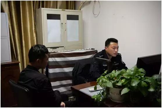 办公室内,值班治安民警解俊正在为一名报警人做笔录.