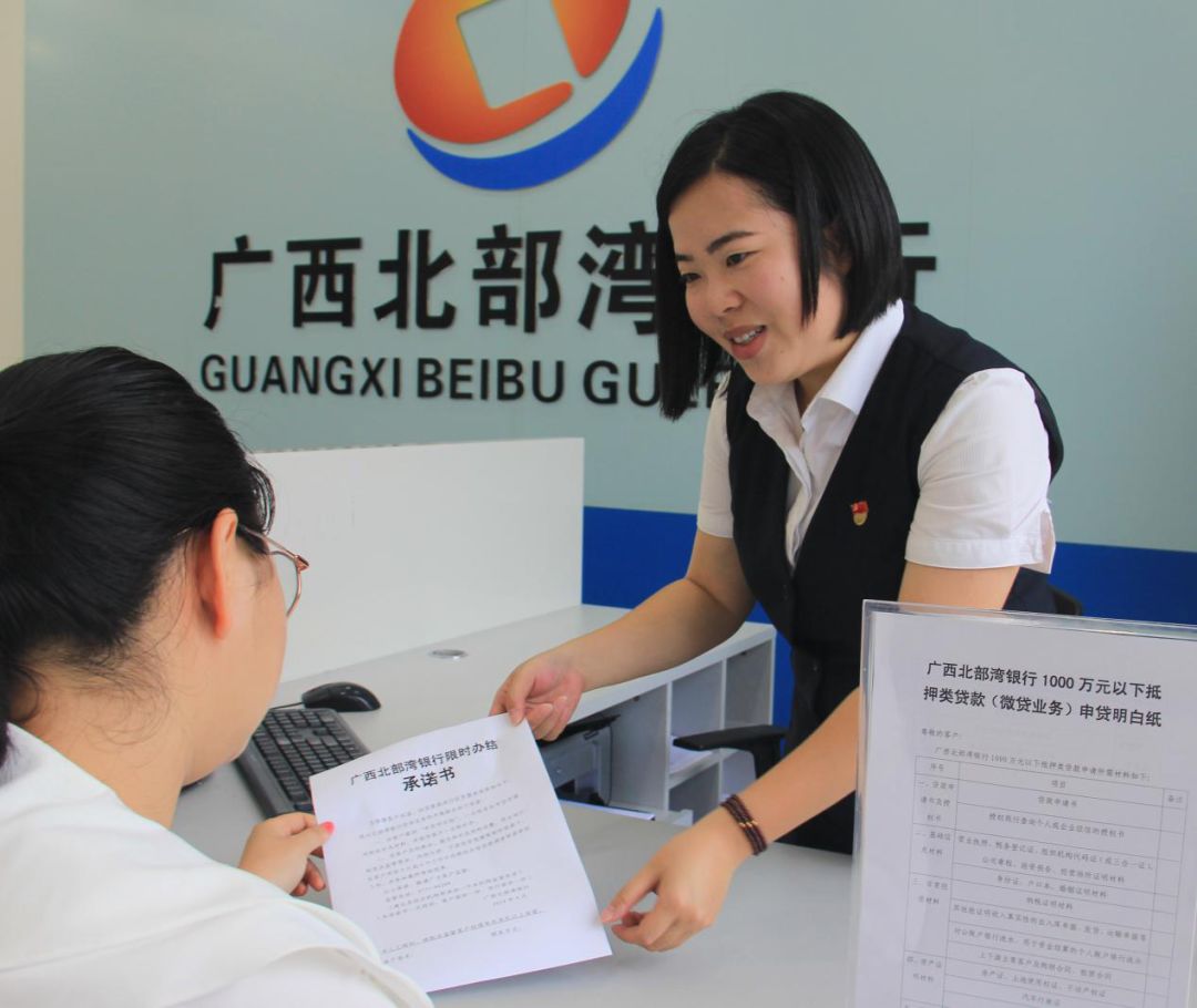 广西北部湾银行网点工作人员向申贷客户介绍《限时办结承诺书》,并在网