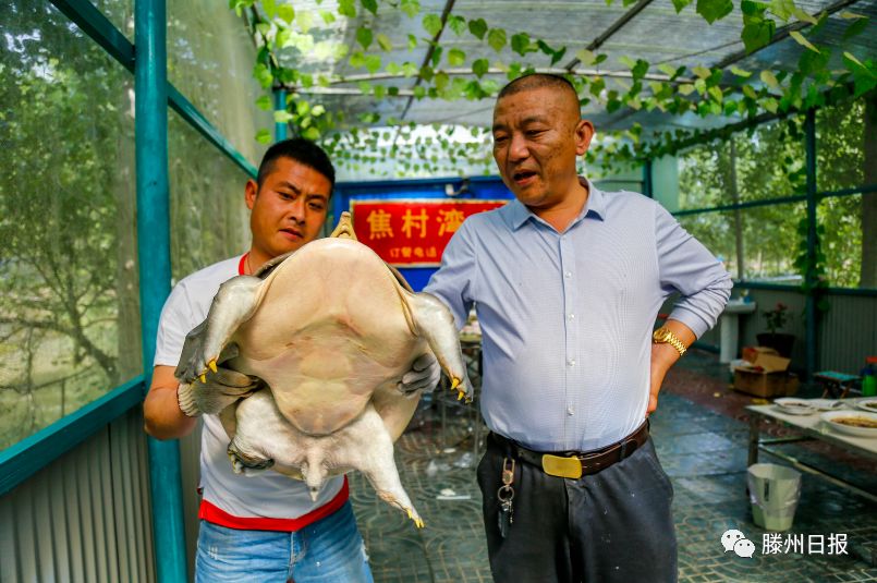 马启中(右)先生向游客介绍捕获大甲鱼的经过