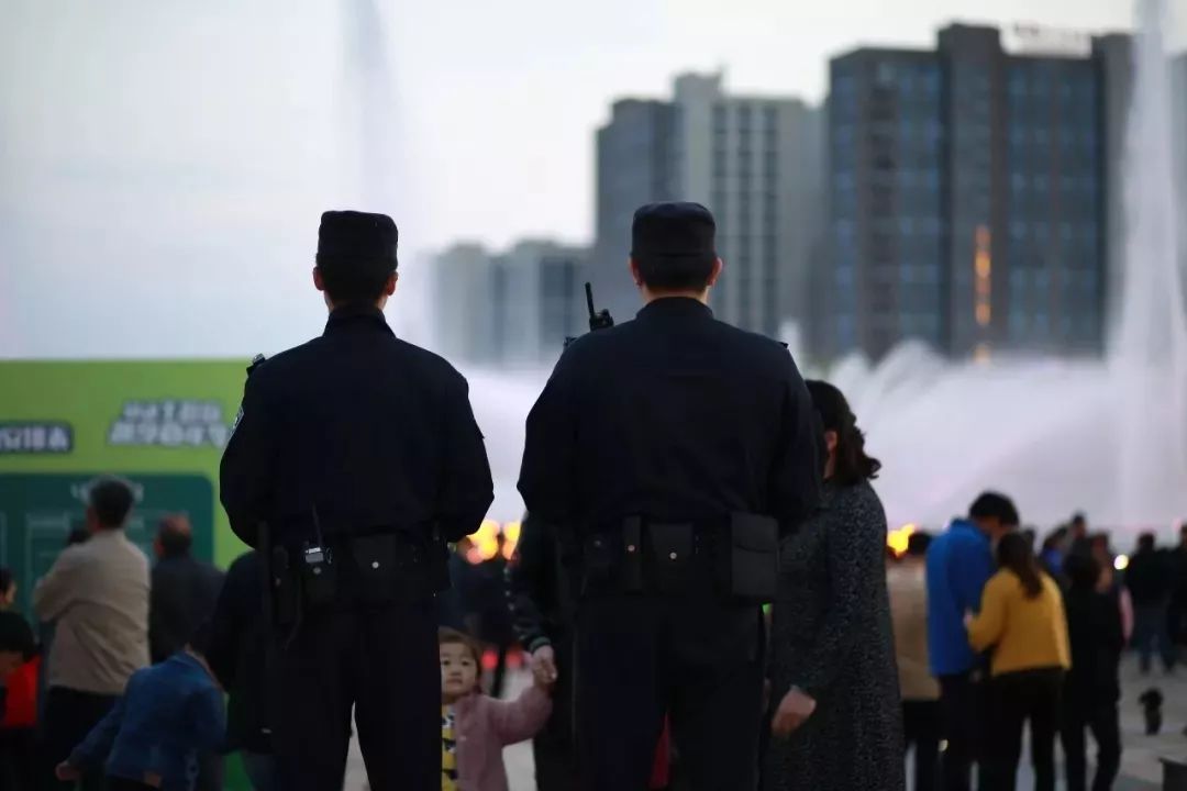 一个中国警察专业的警戒背影 人群在沸腾 香槟喷发着胜利者的激情