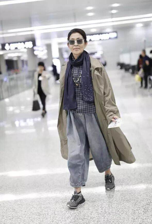 倪萍瘦身后现身机场，一套风衣阔腿裤的气质穿搭，60岁高调美回来