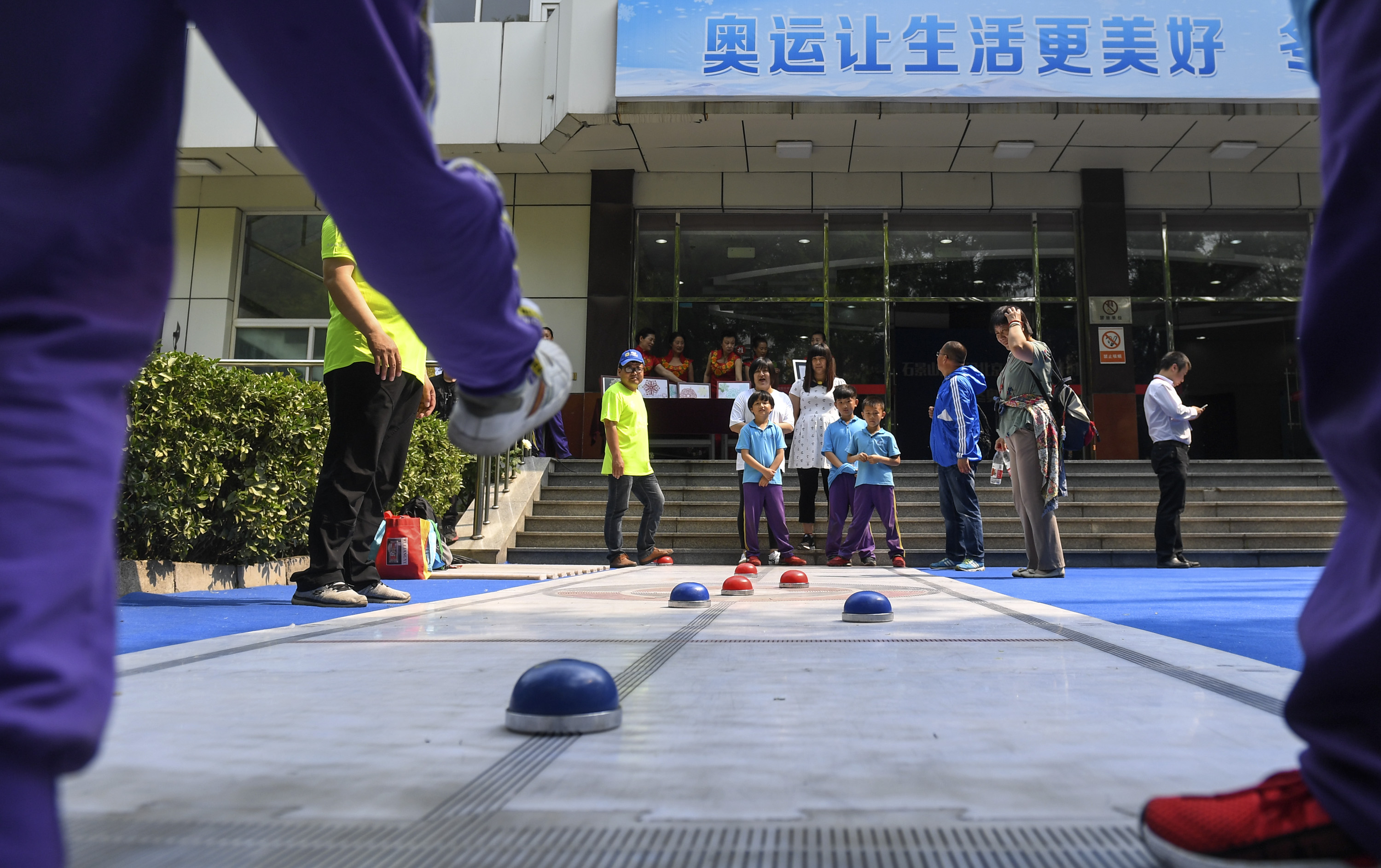 11日,广宁街道高井路社区的孩子们和家长在活动中一起体验旱地冰蹴球