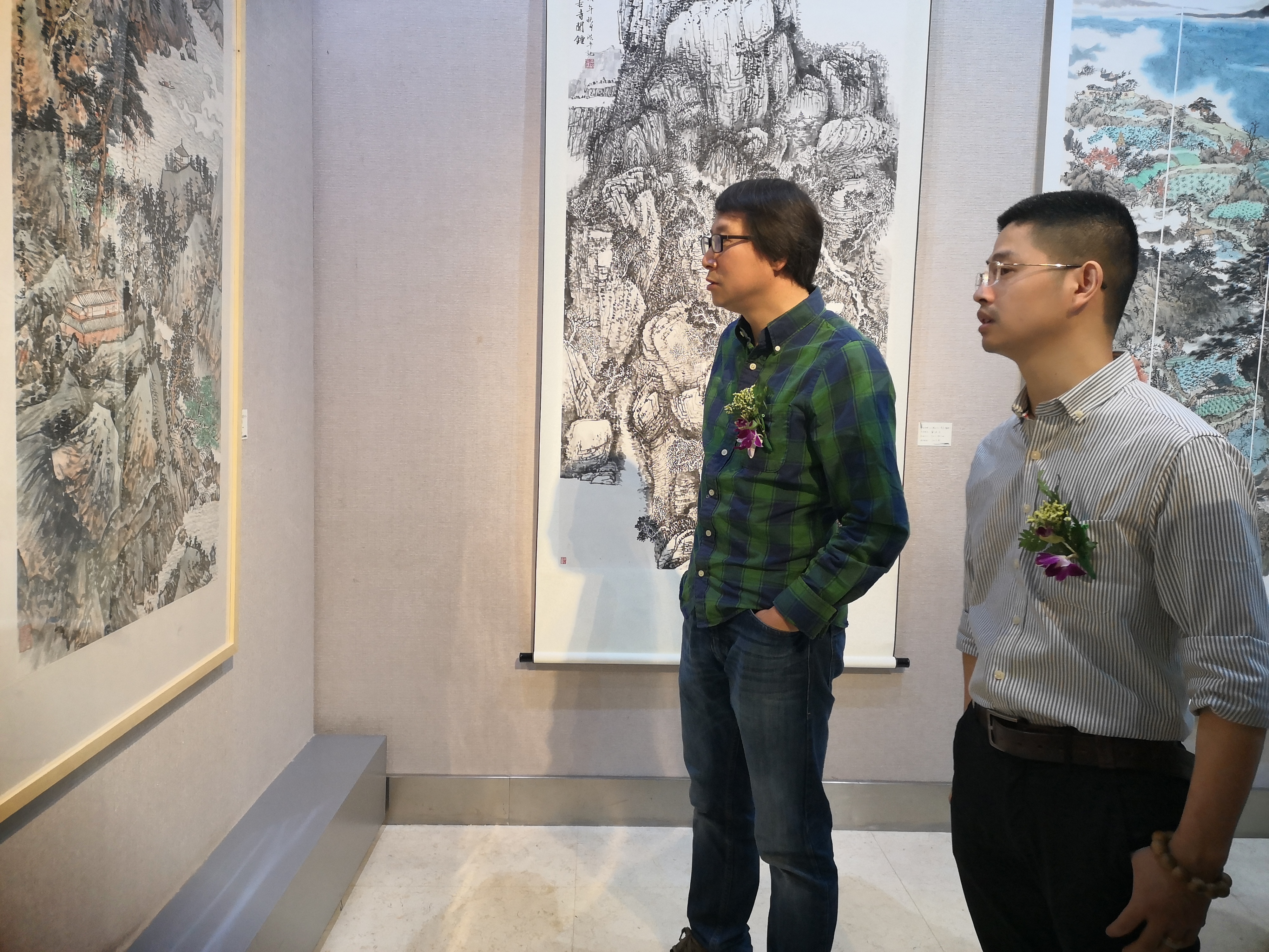 西南大学美术学院段运冬副院长与参展学生鲁君辉一起看展