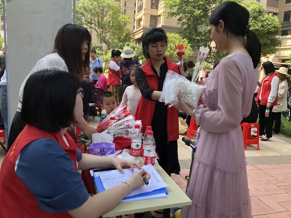社区志愿者为参加活动居民发放康乃馨.符姣 摄