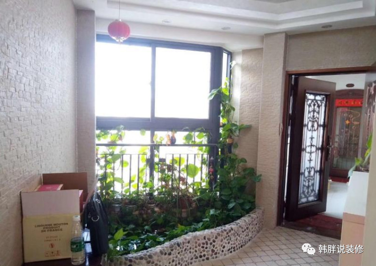 花圃的对面摆放成品的玄关鞋柜,入户花园的天花板装了灯带吊顶,墙壁上