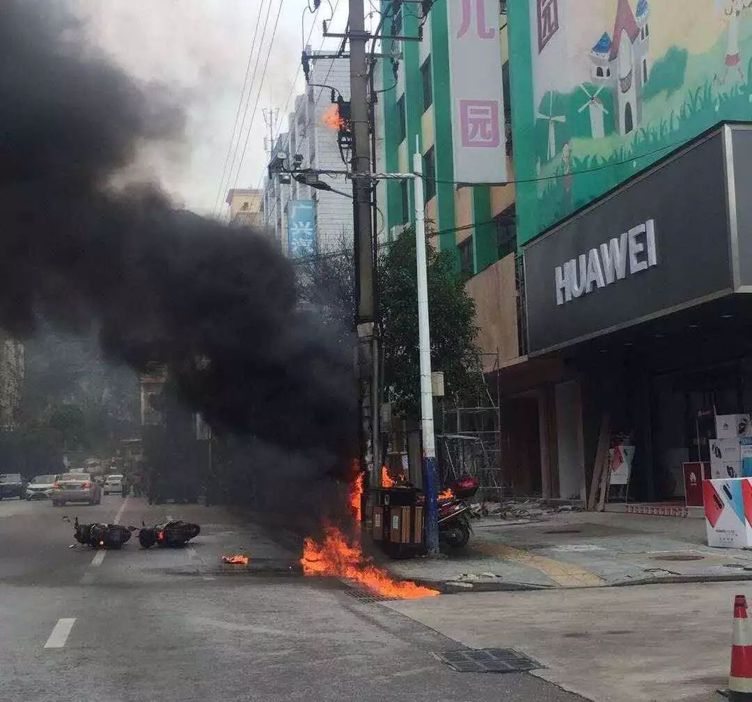 变压器突然爆炸起火,下溅的火花引发放置其下的摩托车着火.