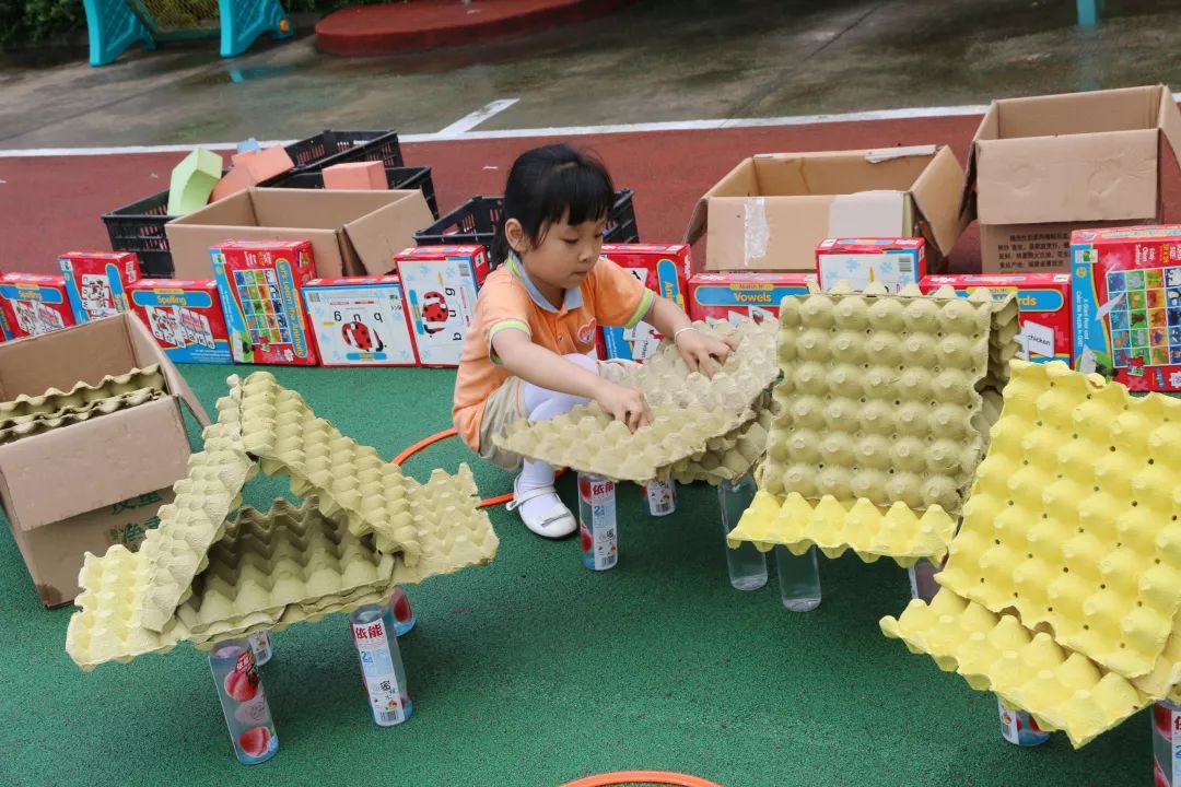 让孩子们在操场上进行建构游戏,使用中大型积塑,奶粉罐,椅子,鸡蛋托