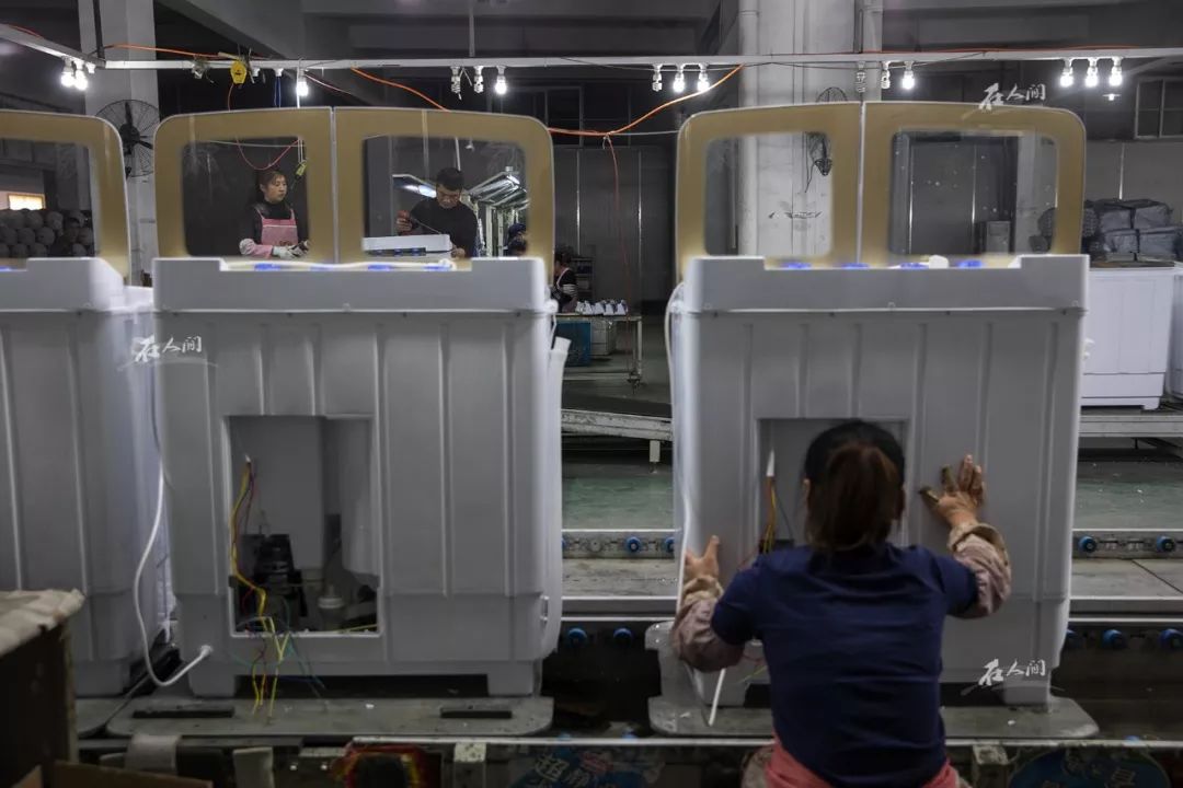 一条流水线上,工人们在生产洗衣机