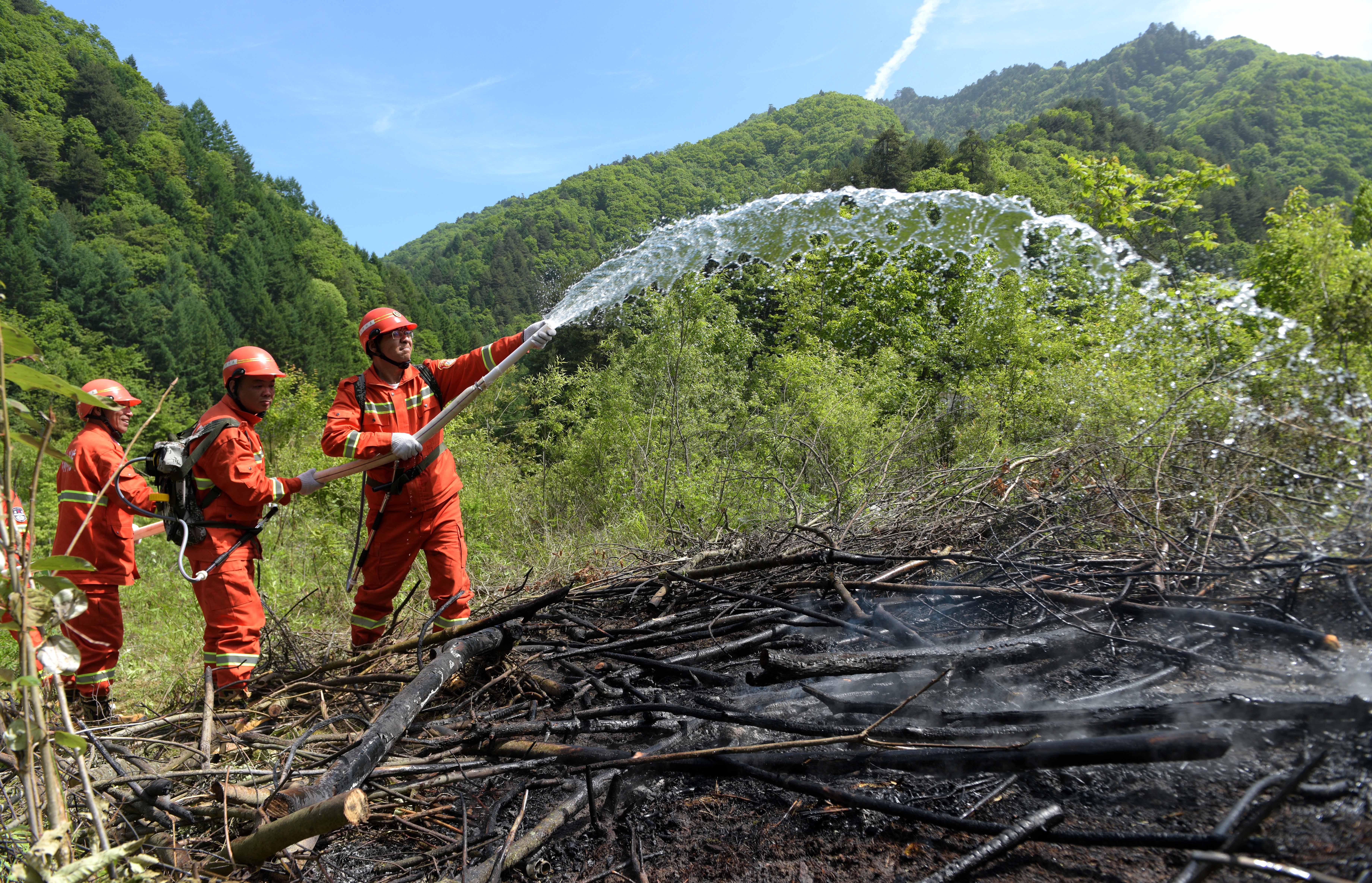 秦岭林区森林火灾扑救演练5月21日,消防人员在进行"余火清理"课目演练