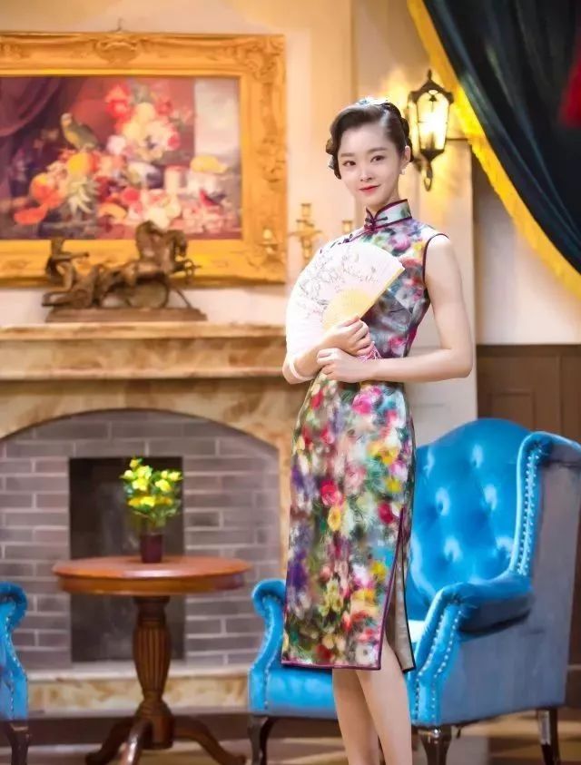 水蓝色印花旗袍将她姣好的身段展露出来,配上复古的发型,手里拿着扇子