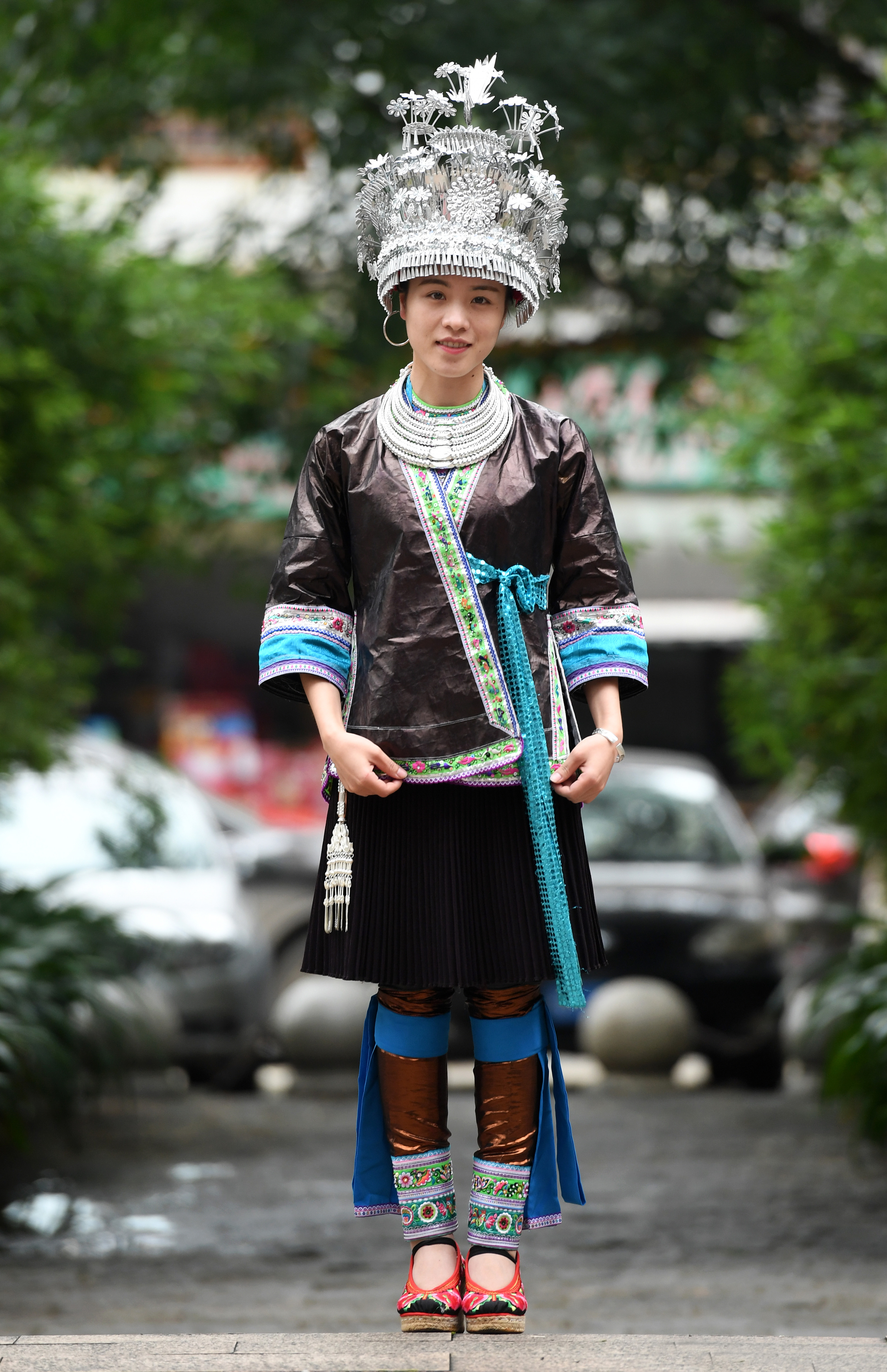 5月29日,在广西融水苗族自治县融水镇,一名女青年在展示苗族银饰.
