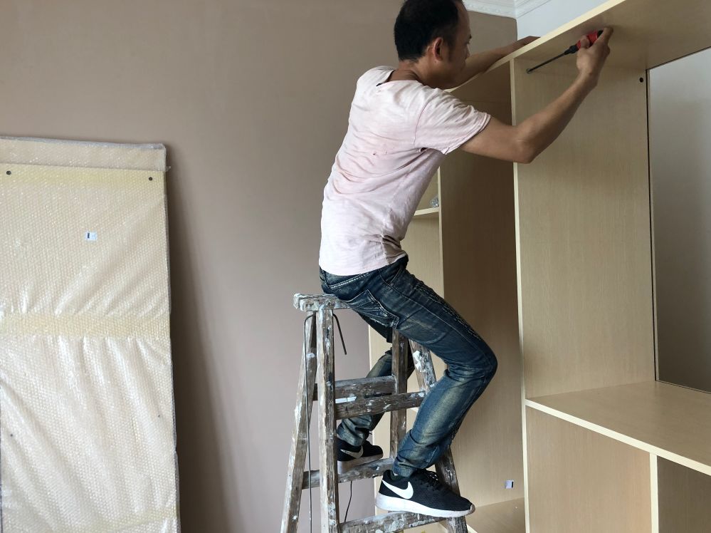 装修工人正在拼装柜子2019年5月15日拍摄| 主卧开始清理| 客厅吊灯