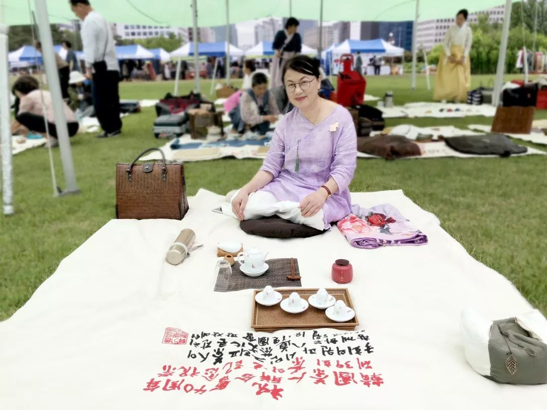 国会大厦前,近千台茶席铺展在绿色草坪上,像一幅巨大艳丽的油画.