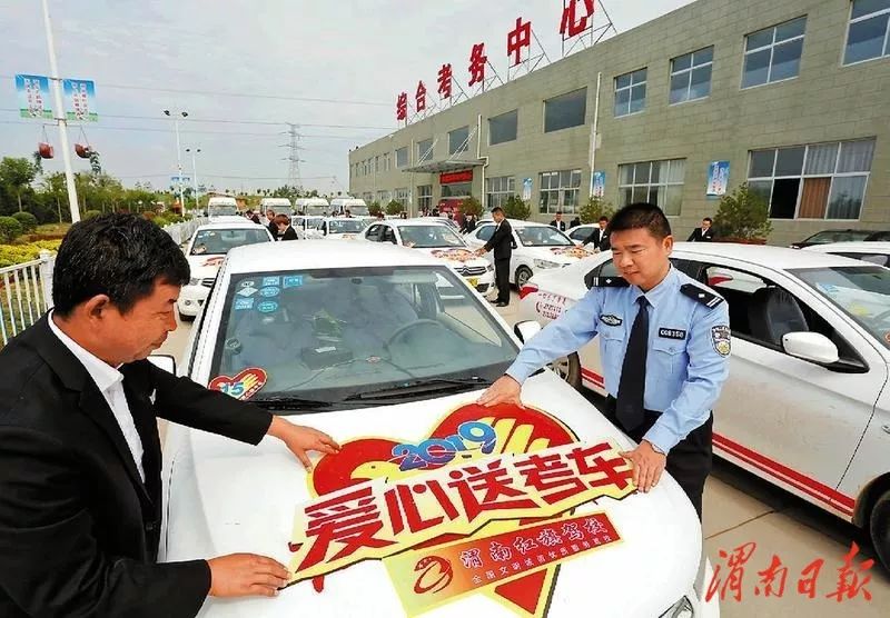 民警和工作人员张贴"爱心送考"车贴