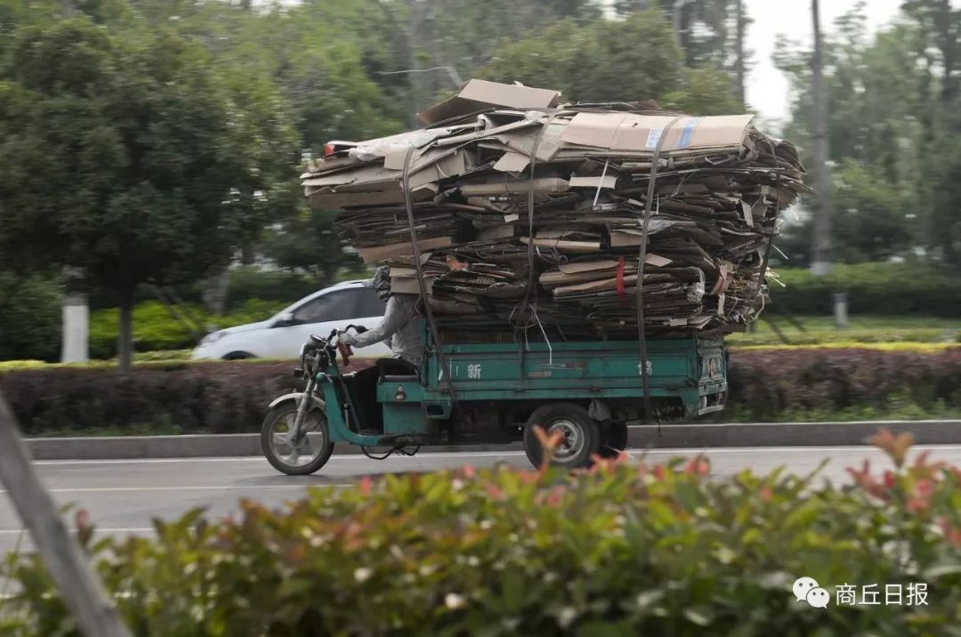 6月3日,一辆超载的电动三轮车行驶在睢阳路快车道上.记者 崔 坤 摄