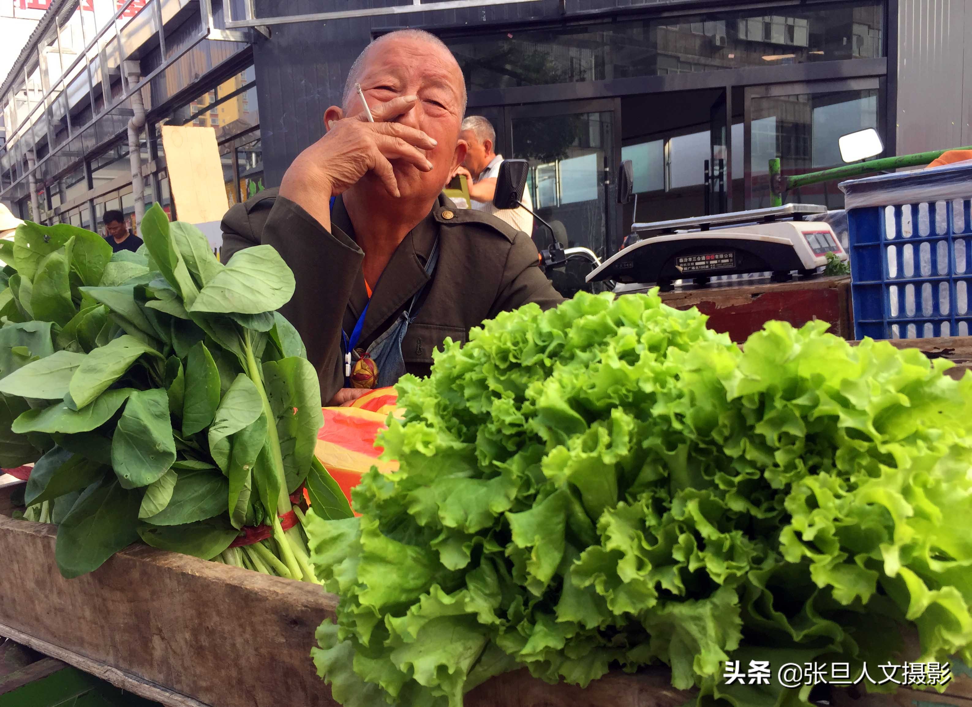 1 12 山西省临汾市一家早市上,卖木菜68岁的黄大叔,满脸喜庆的笑容