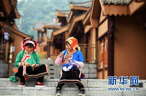 6月6日,两名来自晴隆县三宝彝族乡的搬迁户在阿妹戚托小镇里刺绣.