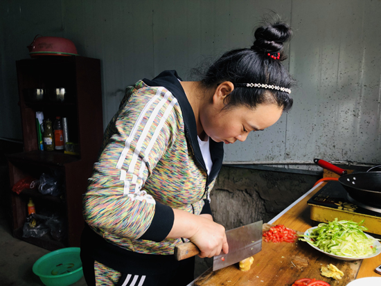 罗国玉在给建档立卡户杨胜付几人做饭