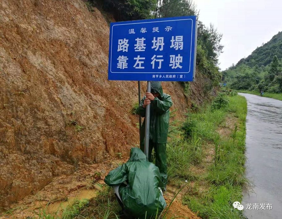 南亨乡干部在路基坍塌路段安装警示牌(谢帅宇)