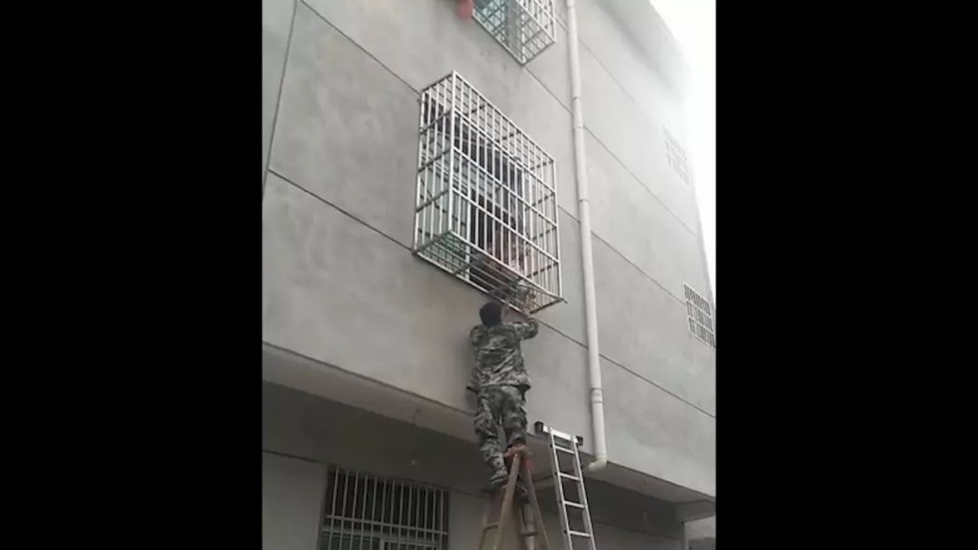 男童上不来又下不去,楼上邻居也赶来帮忙,抓着孩子的胳膊"拎"着他.
