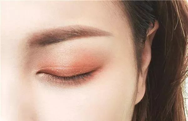 step  :将橘棕色珠光眼影涂抹在上下眼皮打底,靠近睫毛根部的眼影色彩