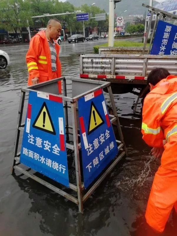 冒雨找到雨水井后,揭掉井盖,放置安全警示牌,提醒广大市民和驾驶员