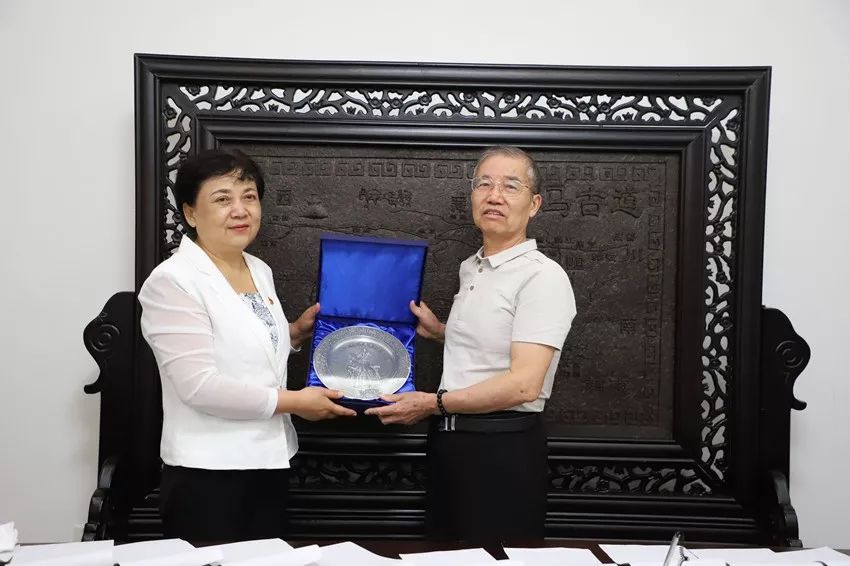 八师副政委魏凤云向王继平一行赠送王震将军像锡盘纪念品