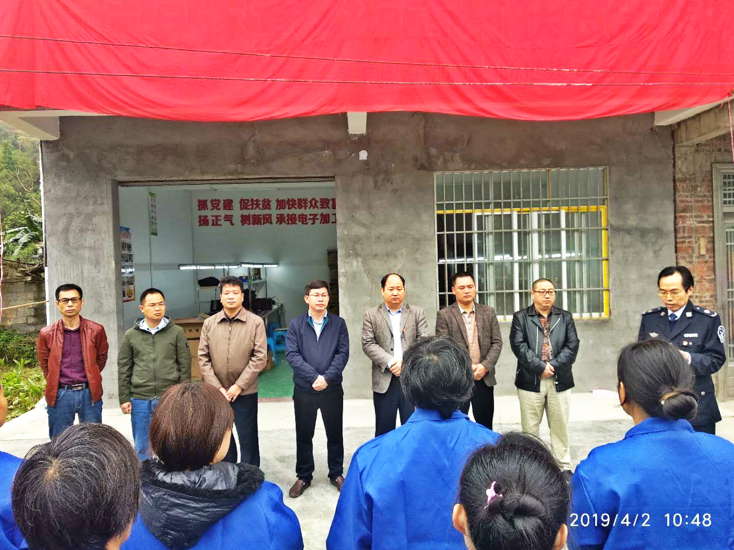 图为忻城县人民政府副县长麦加龙为琼古村扶贫车间落成揭牌