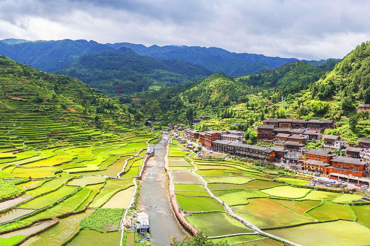 西江千户苗寨四面环山,丛峦叠嶂,梯田依山顺势直连云天,白水河穿寨而