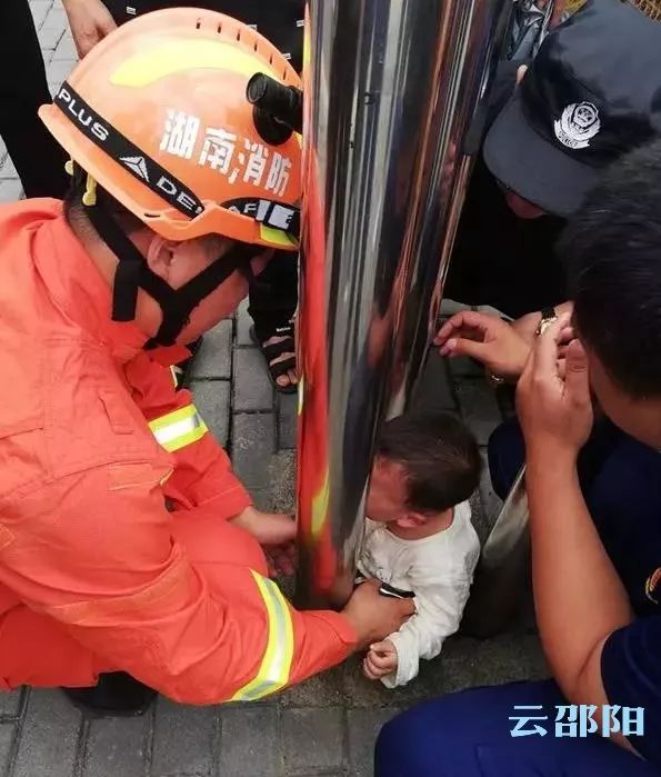 邵阳一小孩身体被广告灯箱卡住，消防队员紧张救援......:消防队员