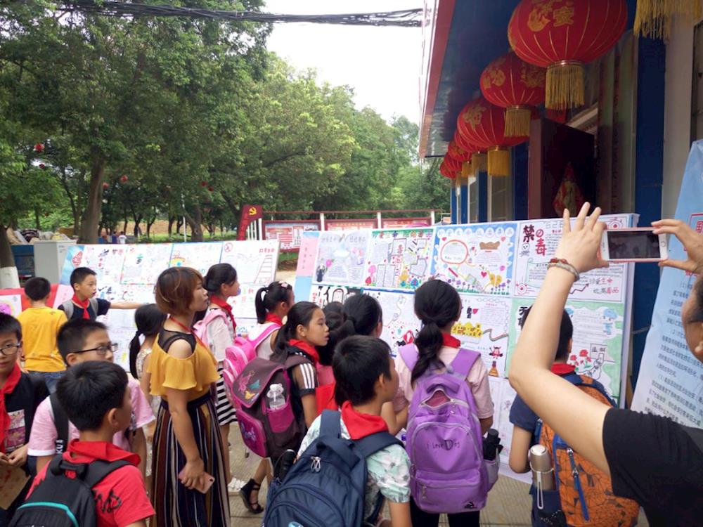 欣赏完手抄报,同学们纷纷来到禁毒"签名墙"前,郑重地签上自己的名字