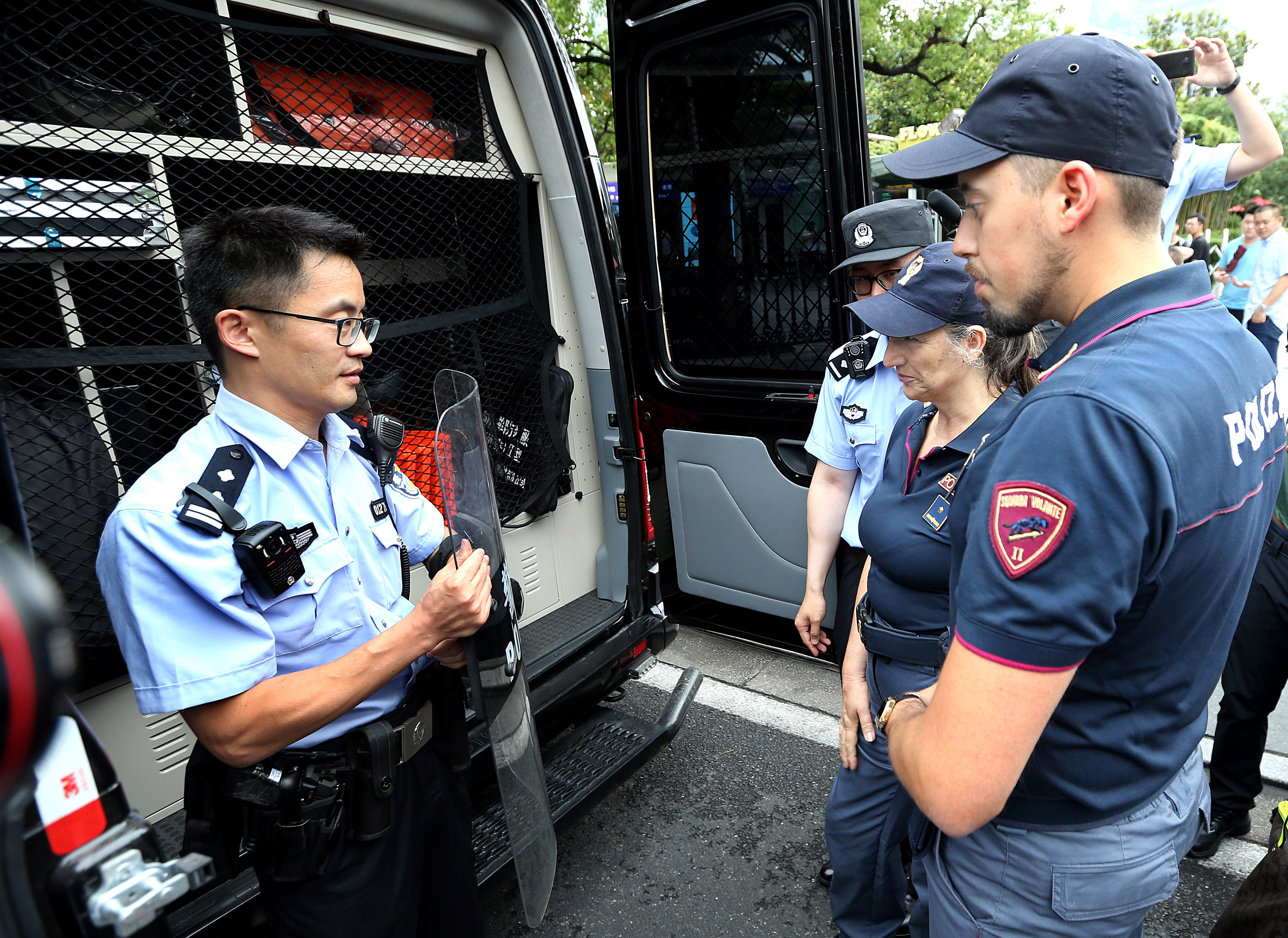 6月26日,上海市公安局浦东分局民警在向意大利警员介绍警用装备.