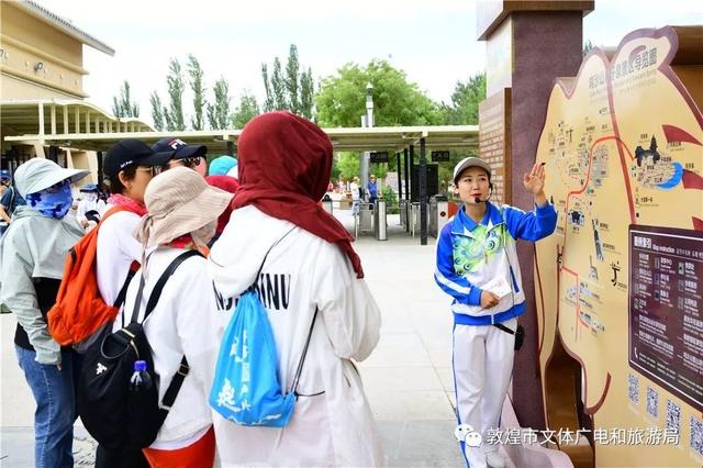 鸣沙山月牙泉景区讲解员为游客介绍景区最佳旅游线路及所用交通工具.