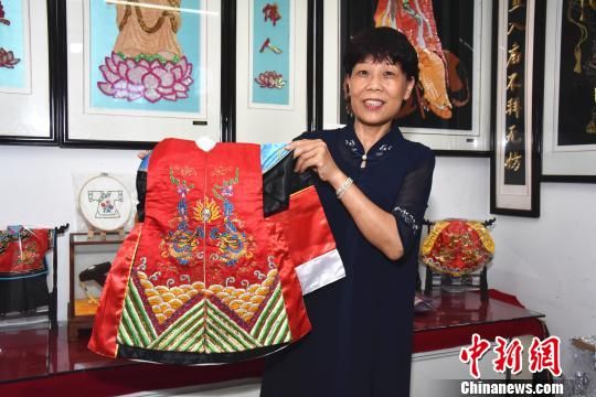 闽南"绣娘"陈克忍展示用金苍绣技艺制成的木偶戏服.陈龙山 摄