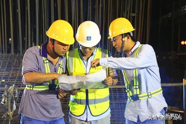 图为工程部施工员指导现场作业人员按图施工