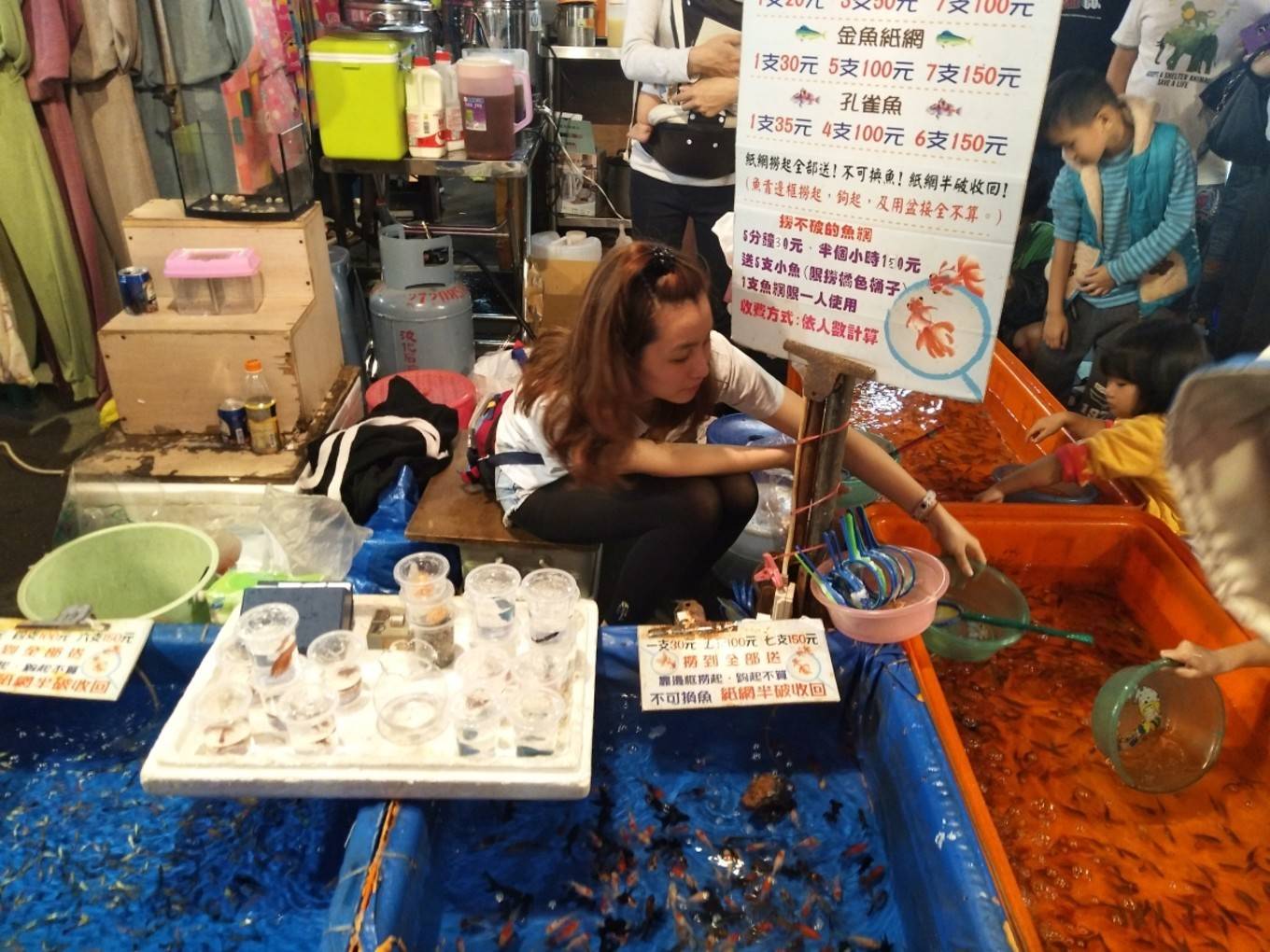 夜市里还有捞金鱼的摊位,吸引很多小朋友.