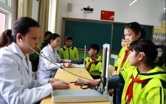 黔西县中医院医生为该县特殊教育学校学生测量血压.杨斌摄