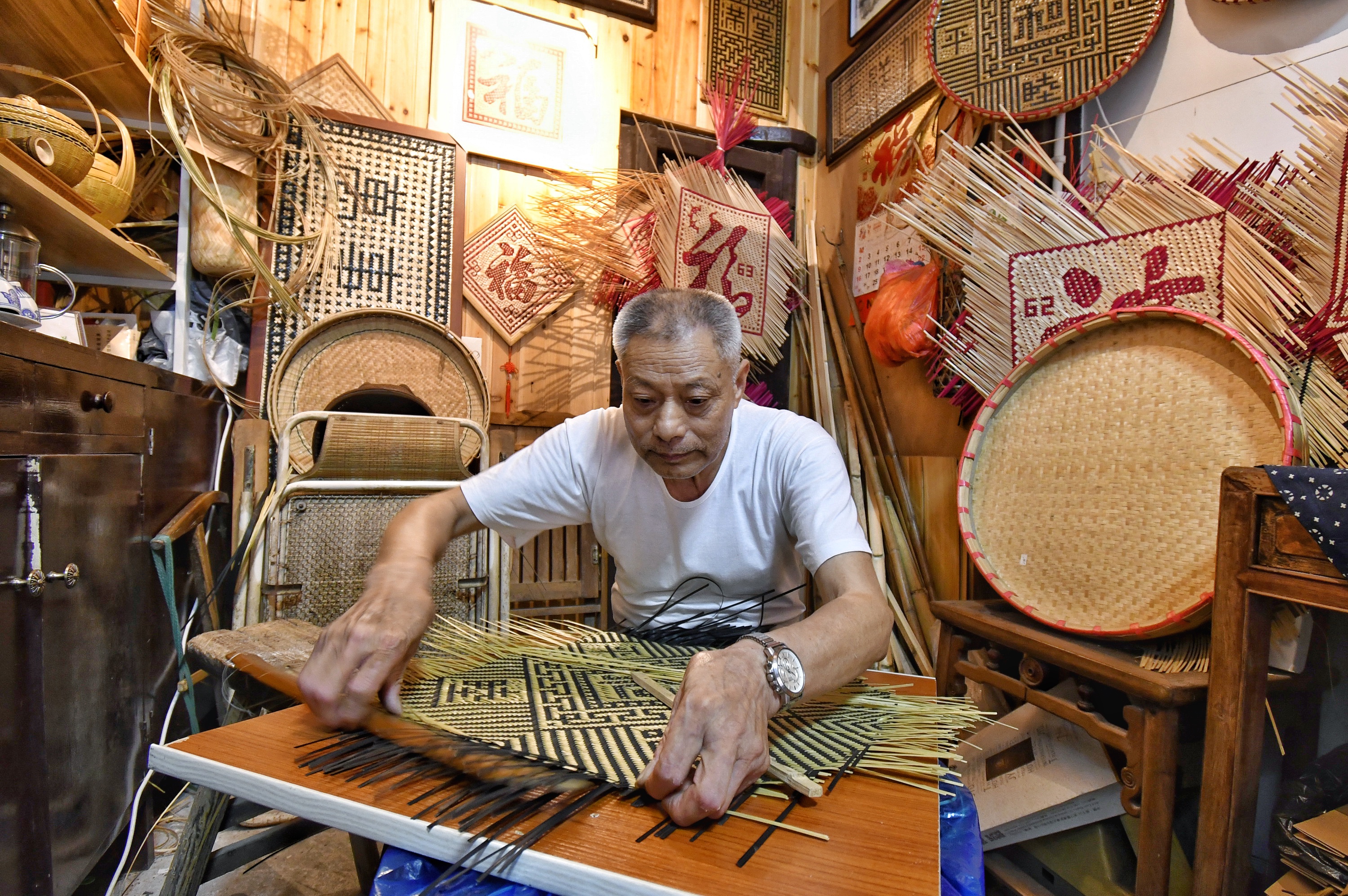 7月4日,马吉林在德清县新市镇自己的竹编店铺制作竹编.