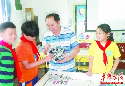 6月19日,盘石完全小学创客基地,綦恒柏右二给孩子们讲解机器人相关