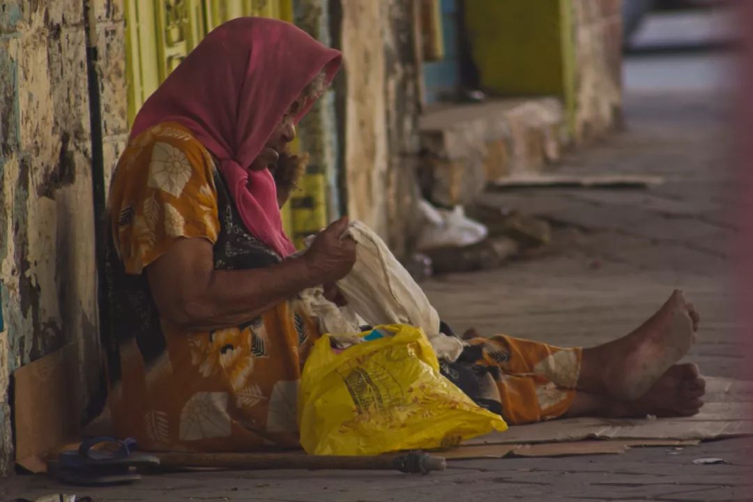 一个无家可归的女人坐在位于也门南部的沿海城市亚丁(aden).