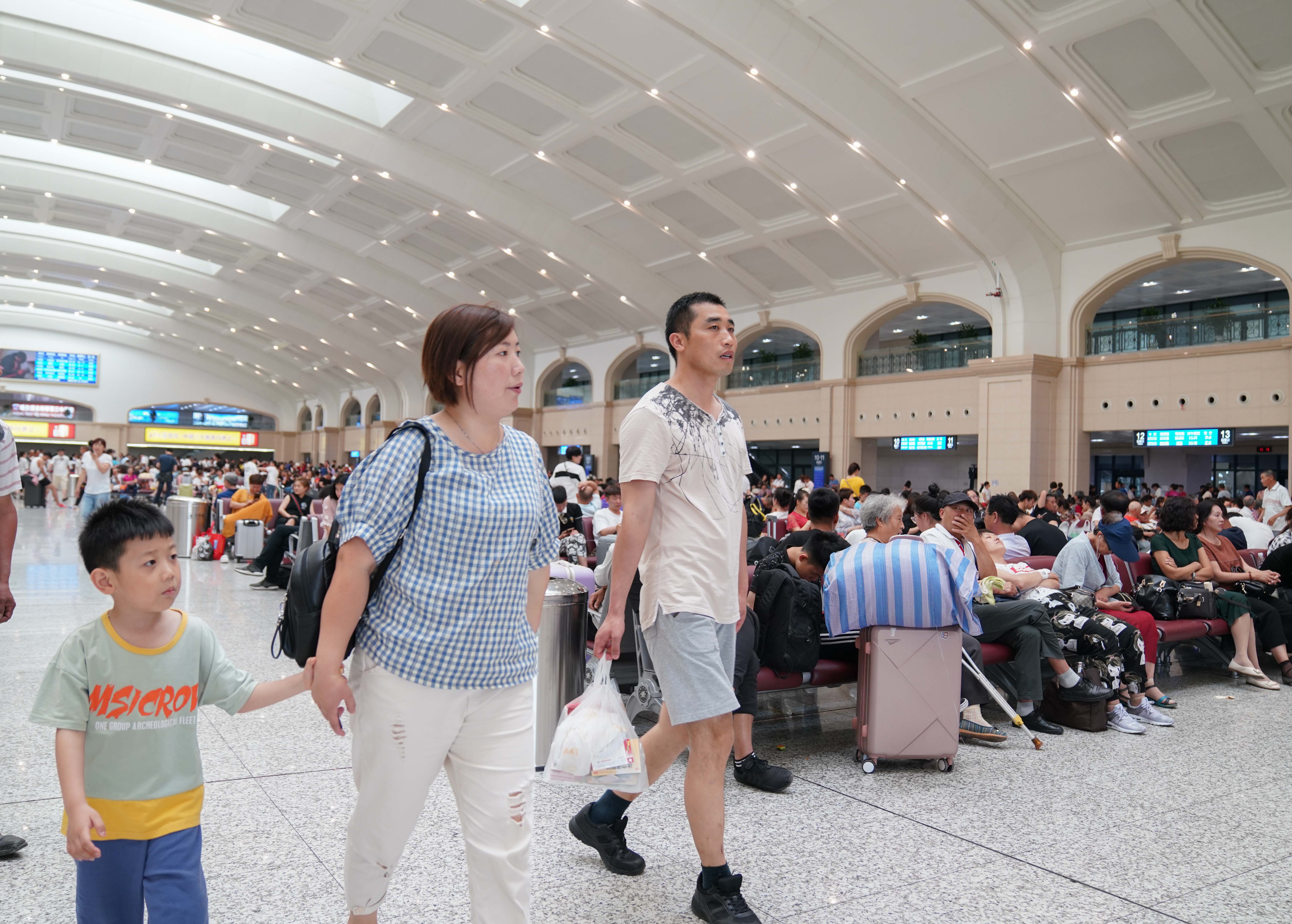 7月11日,乘客在哈尔滨火车站候车室候车.