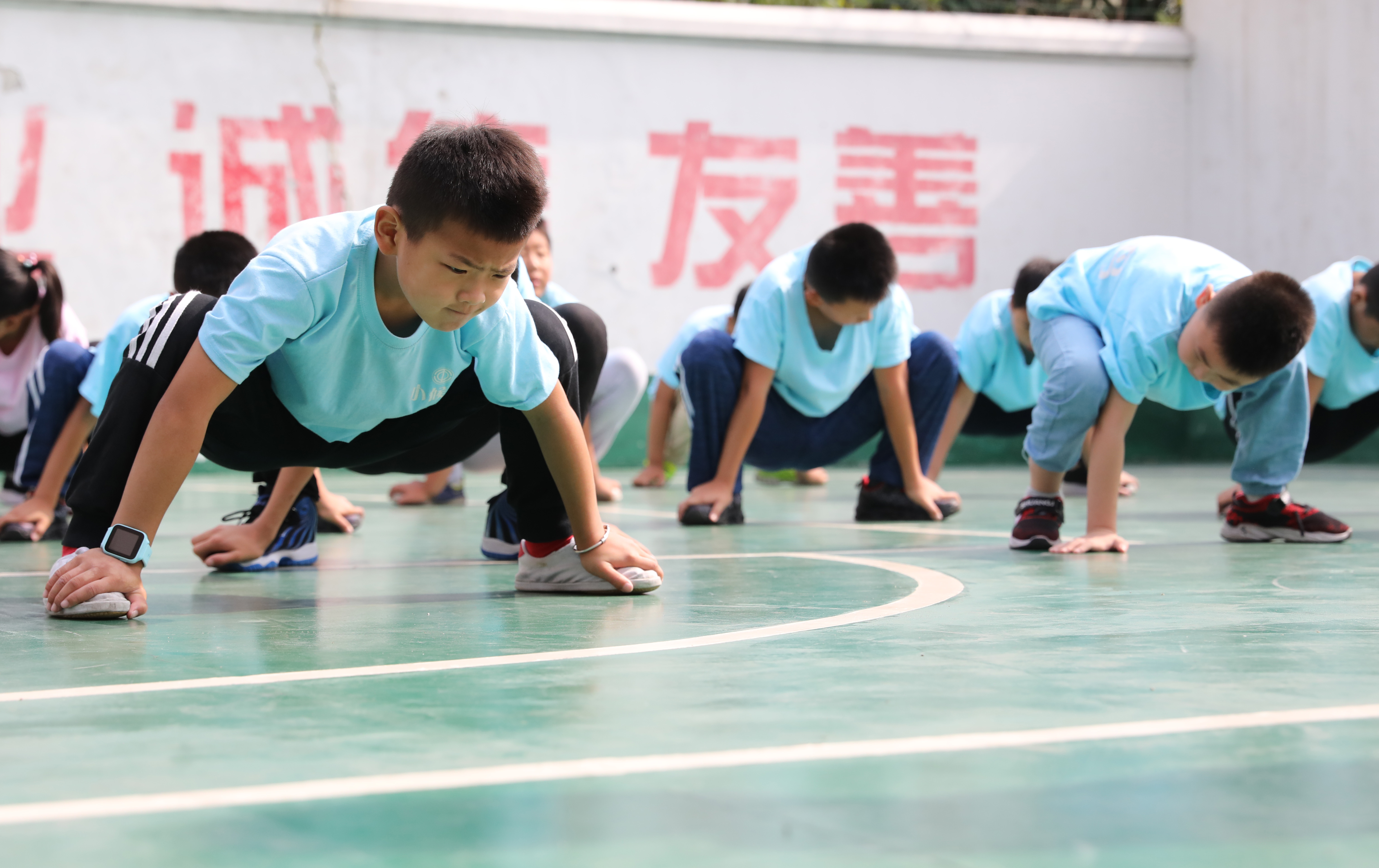 "小候鸟"们在武术课前做热身运动(7月15日摄).