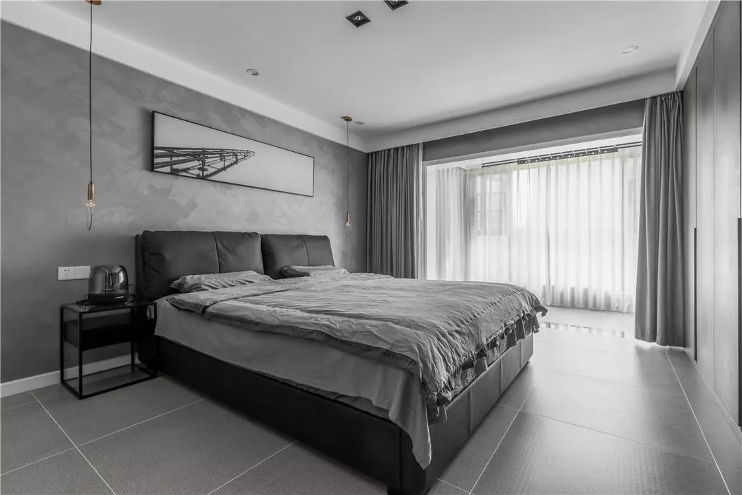 主卧室是在灰色的墙壁和地砖,床单上,结合黑色的床和床头柜,而床头柜