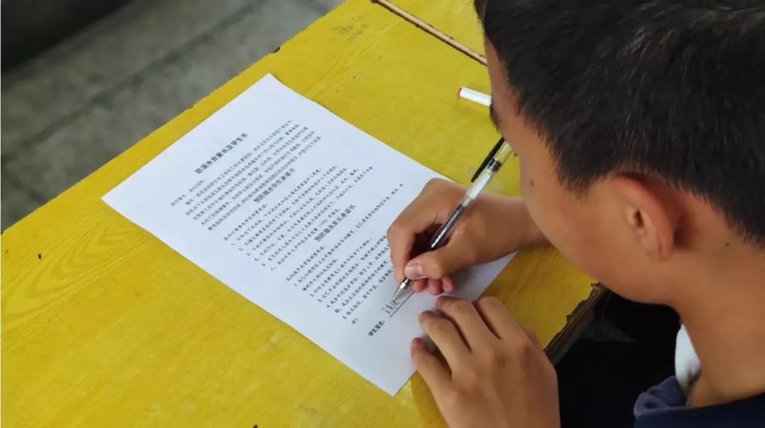 同学们在《预防溺水学生承诺书》上签名【镜头二】洪山区实验幼儿园：节