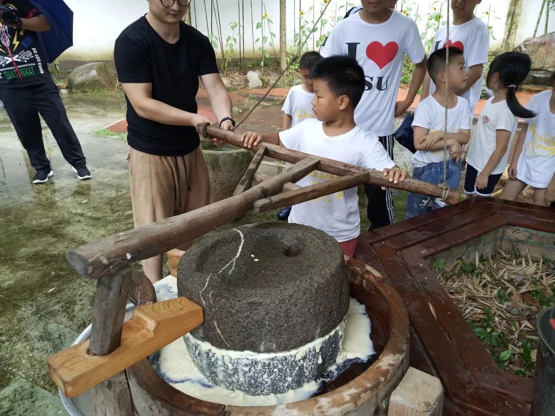 july 9舀一勺黄豆加进去小朋友们便跃跃欲试了磨豆腐可不是一件容易的