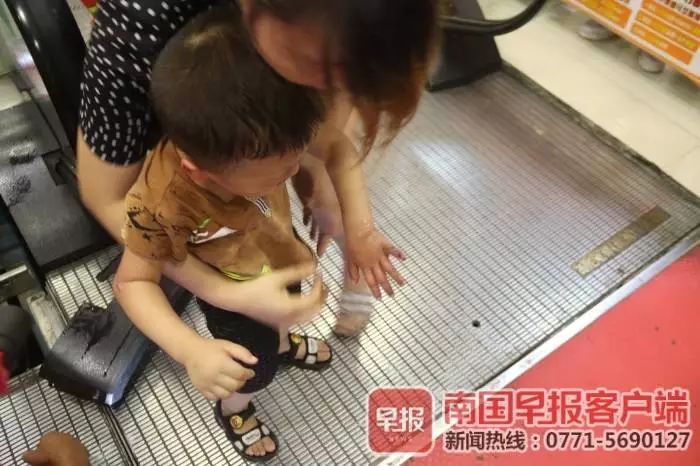 小男孩获救后,他的左手掌有些红肿,尾指部位也有夹伤的痕迹,他的母亲