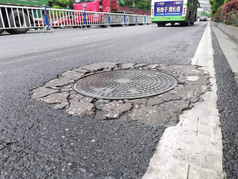 主要是因为城市道路在设计建造时,把排水管道的检查井室建在了主路面