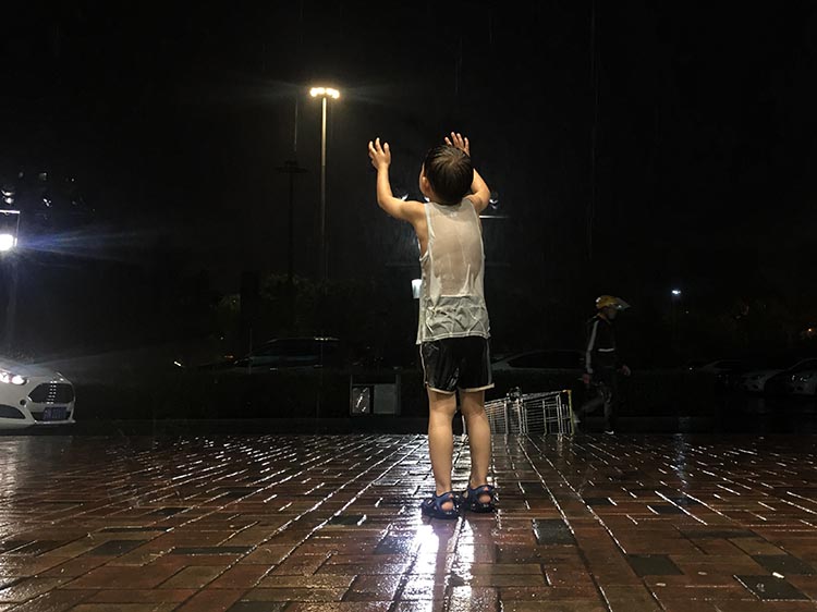 分钟寺,男孩在雨中玩耍,衣服全部湿透.